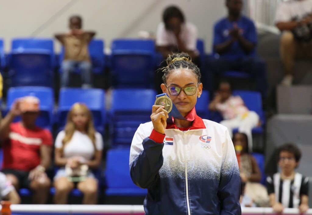 Ana Rosa García sostiene su medalla de oro en el podio de judo de Santo Domingo 2026, con la chaqueta del Comité Olímpico Dominicano.