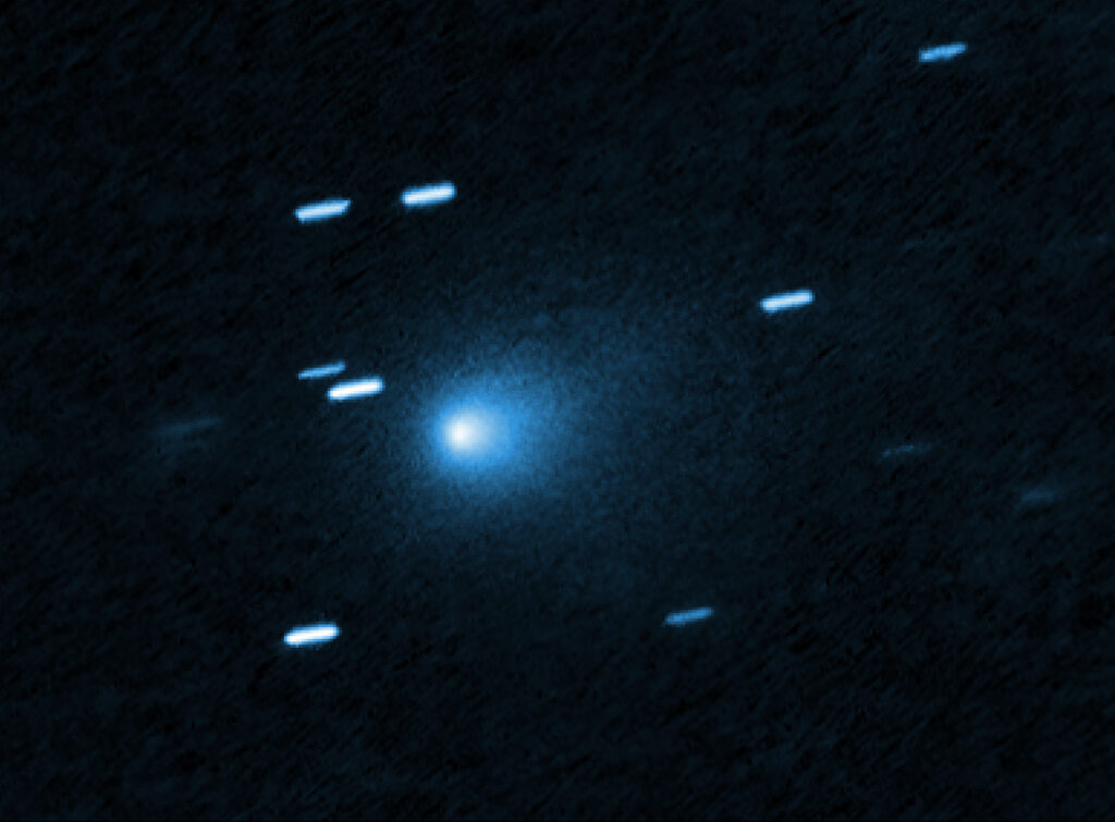 Qué encontró el telescopio Webb en el cometa interestelar 3I/ATLAS Imagen del telescopio espacial Hubble del cometa interestelar 3I/ATLAS, visto como un punto brillante con un halo azul claro, contra un fondo de estrellas en forma de rayas